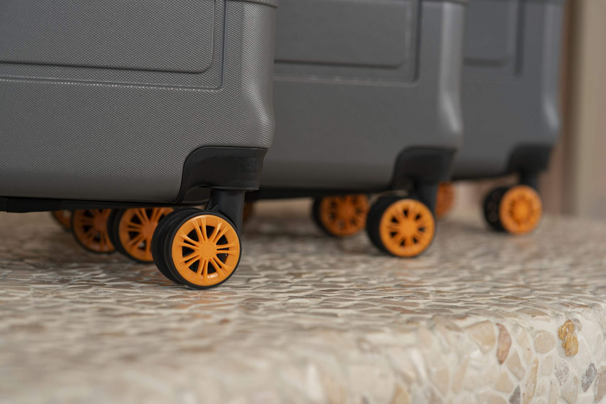 Row of wheeled suitcases from various durable brands on a table