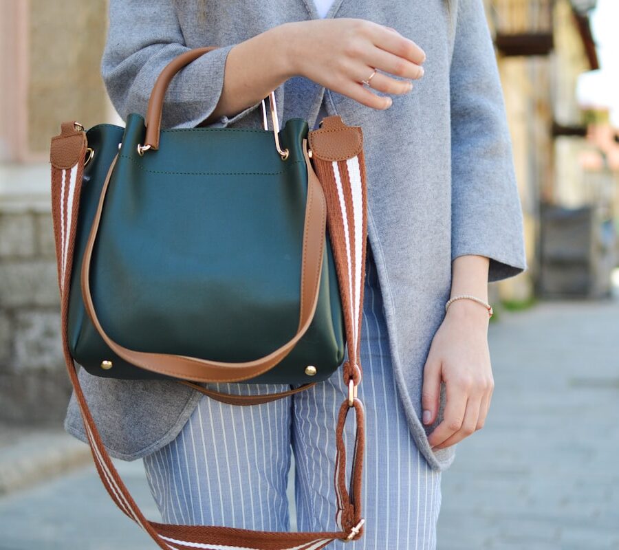 Sustainable luxury leather brands — artisan hands stitching full-grain leather in an ethical workshop