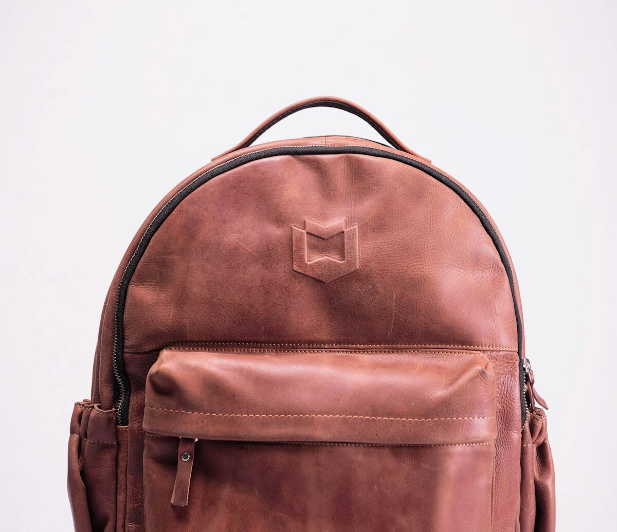 Luxury leather duffel bags for travel — full-grain leather holdall on a wooden floor