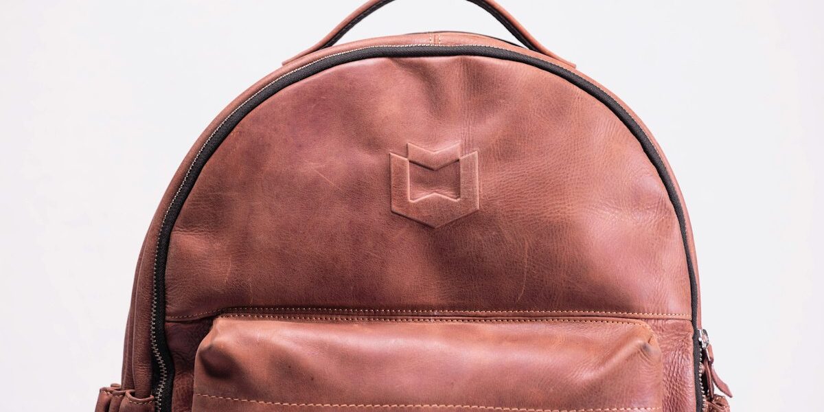 Luxury leather duffel bags for travel — full-grain leather holdall on a wooden floor