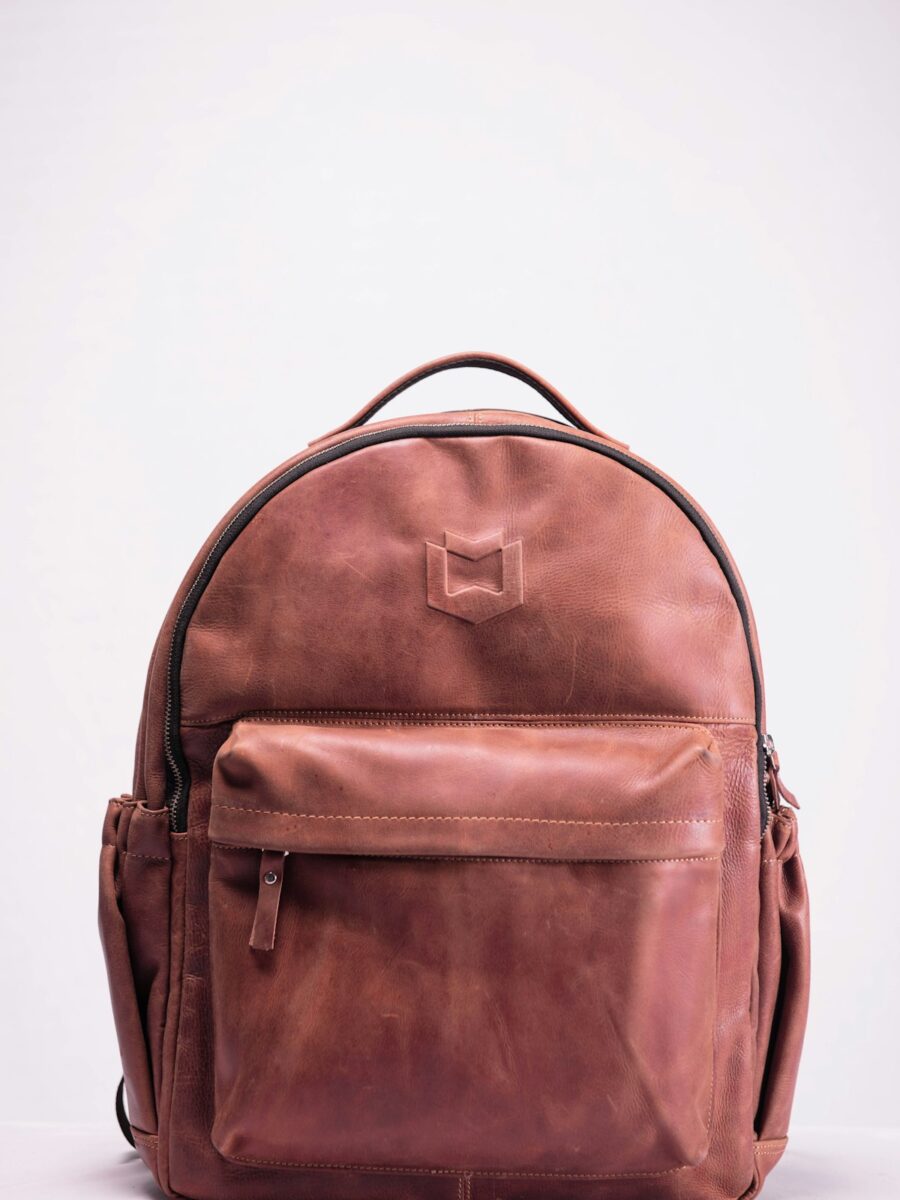 Luxury leather duffel bags for travel — full-grain leather holdall on a wooden floor