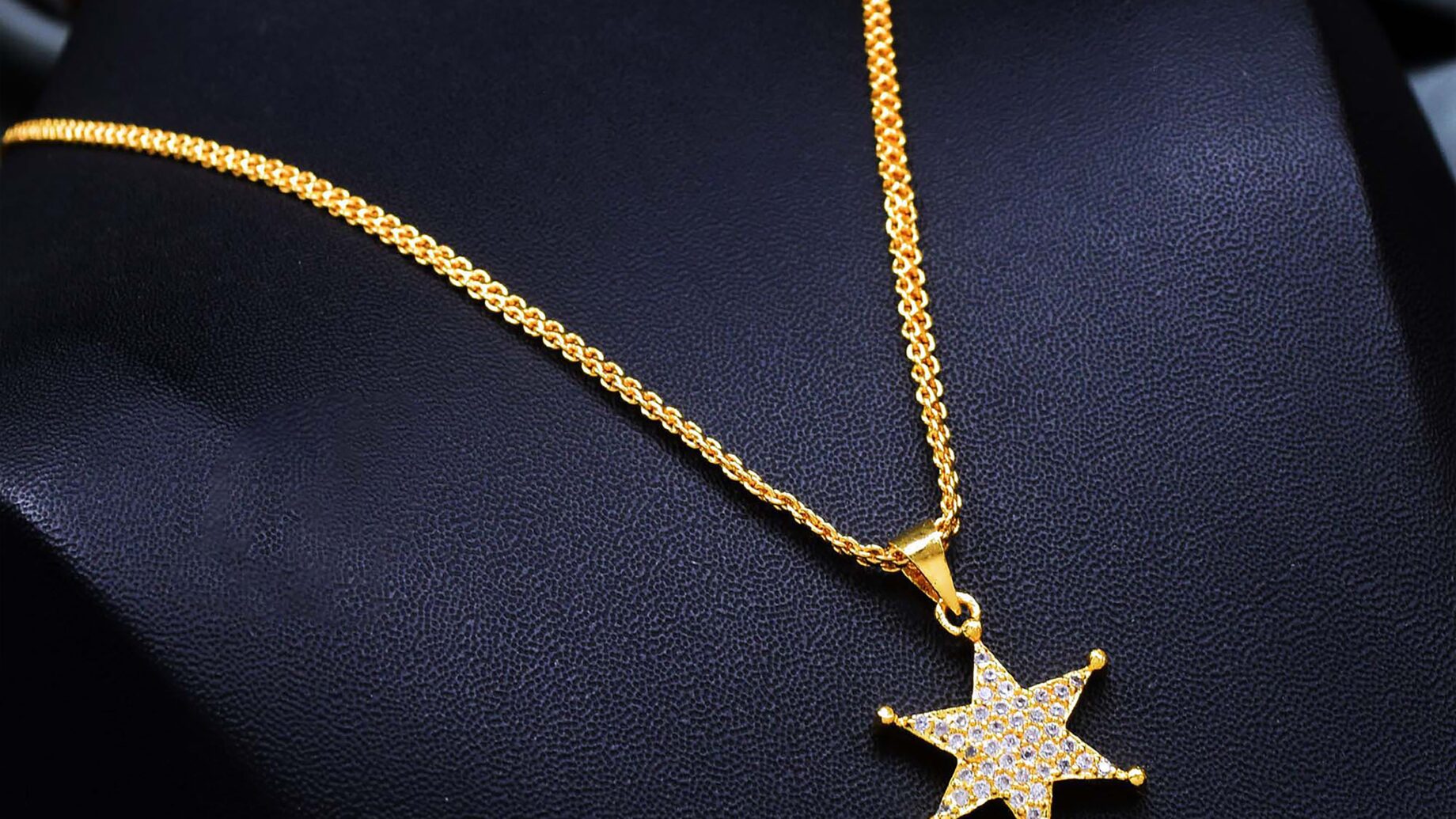 Gold pendant necklace with diamonds on a display stand, a fine jewellery gift