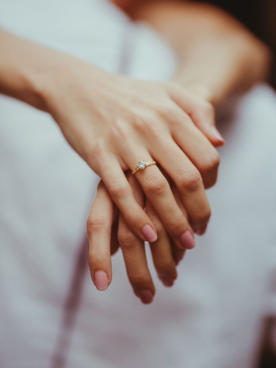 Diamond engagement ring on a woman's finger in soft natural light