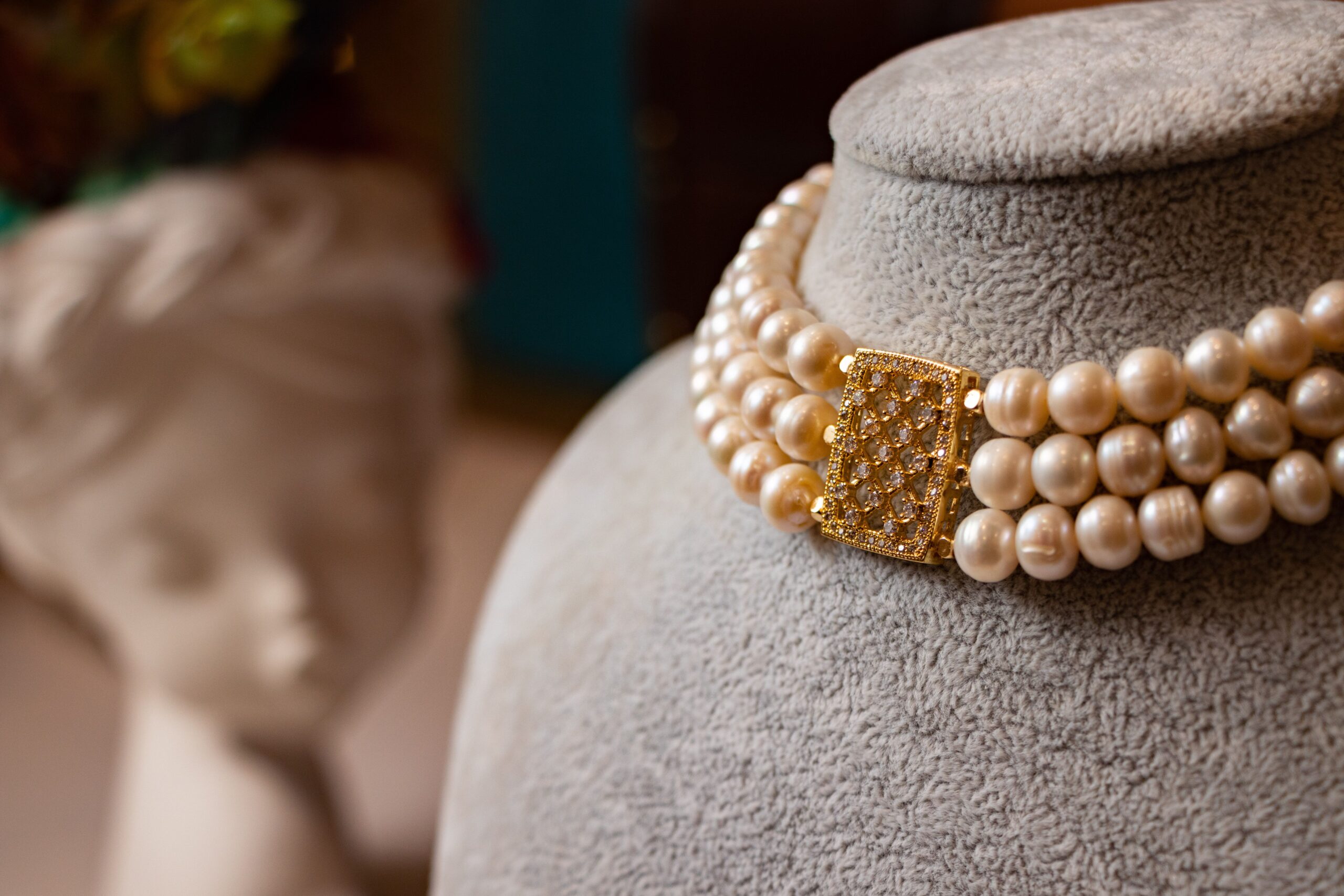 Luxurious pearl necklace with a golden clasp on a display bust