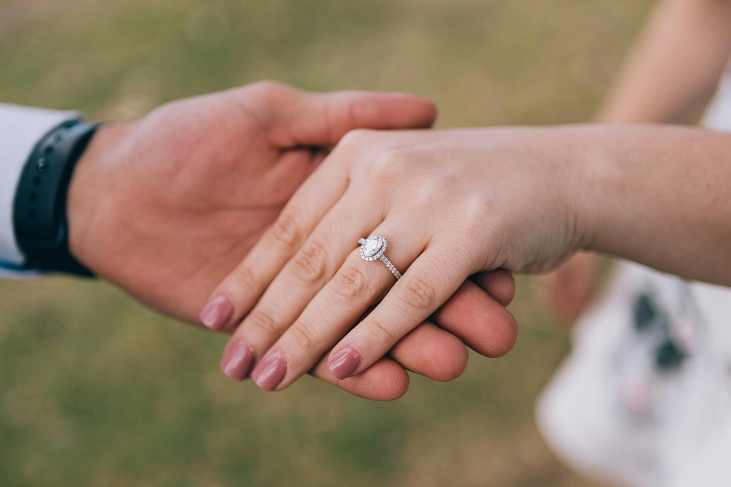 Une bague de fiançailles et une alliance portées ensemble à la main