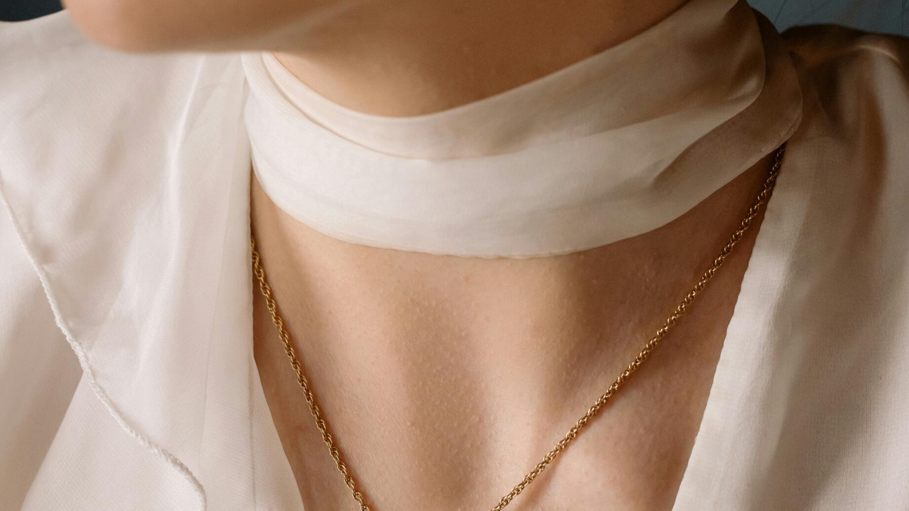 Woman wearing a delicate gold pendant necklace, an elegant gift